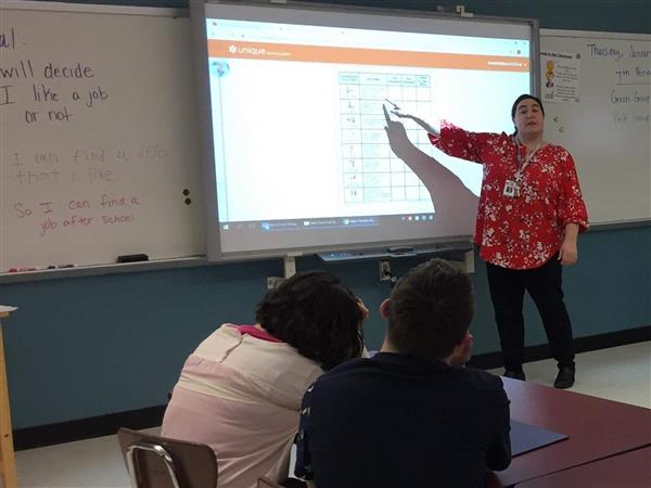 Picture shows Mrs. Garnett pointing to activity on the Smartboard in front of the class.